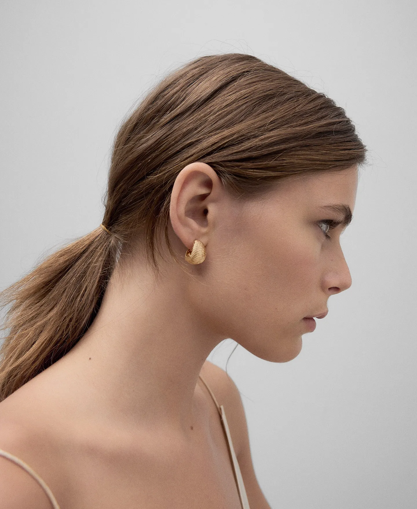 Golden hoops with a shell relief woman